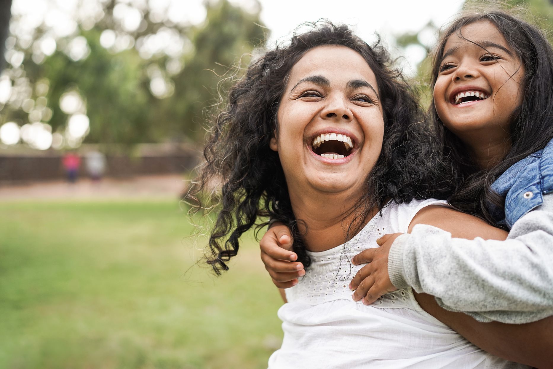 mother-daughter-smiling-outdoors-7d884281db614313bf629048299e7384